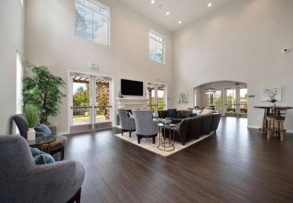 A living room with a grey couch and a wooden floor.
