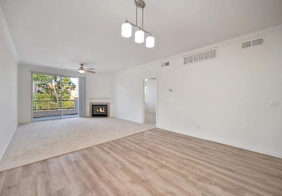 A spacious living room with a fireplace and sliding glass doors.