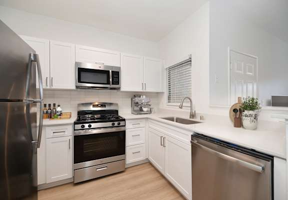 A modern kitchen with stainless steel appliances and white cabinets.