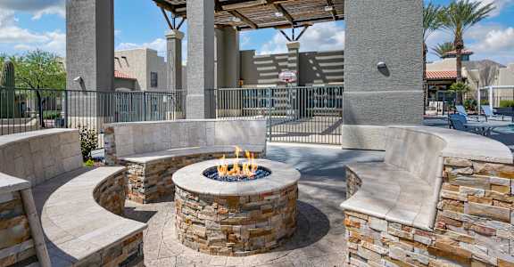 A patio with a fire pit and seating area.