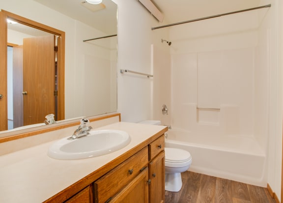 A kitchen with wooden cabinets and a white oven. at Eighth Street Manor  Apartments, Fargo, ND