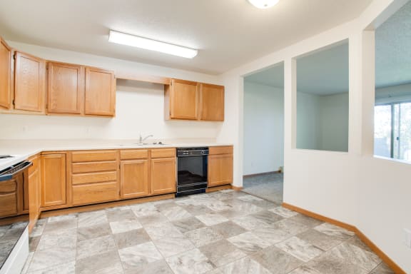 a kitchen with wooden cabinets and a black and white dishwasher