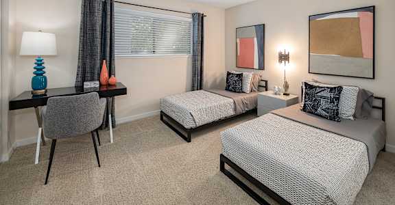 Bedroom with two beds and a desk with a chair  at Silverstone Apartments, Davis