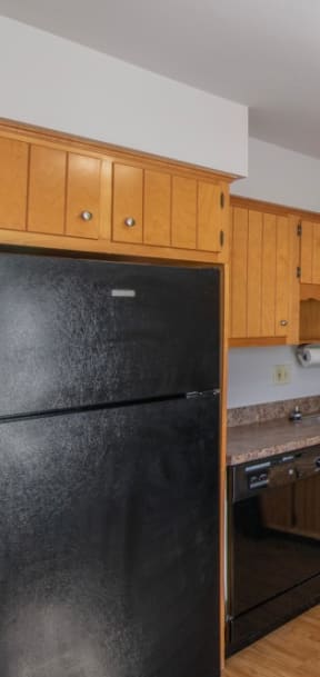 a kitchen with white cabinets and a black stove and refrigerator