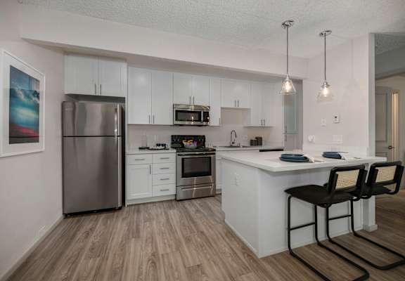 a kitchen with white cabinetry and stainless steel appliances at Pinecrest Apartments, Davis ,95616