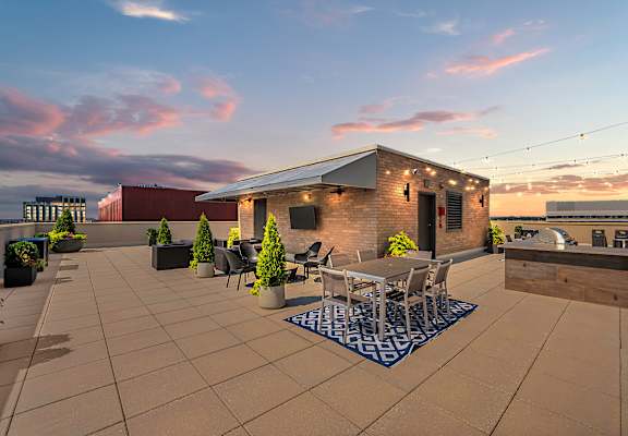 A patio with a table and chairs is set up on a rooftop.
