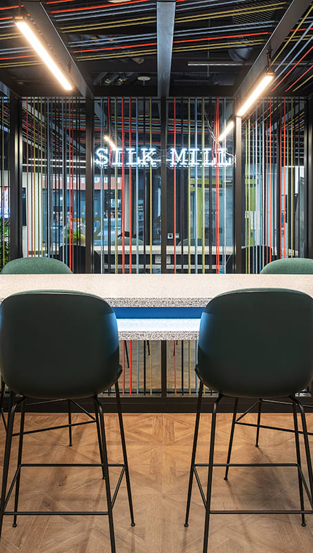 two green chairs sitting at a table in a room