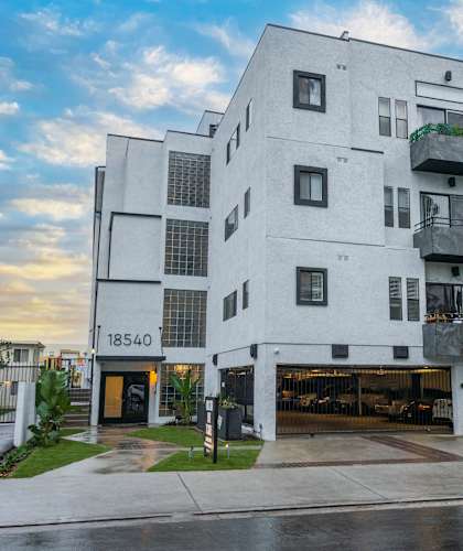 a large white building with two balconies and a garage