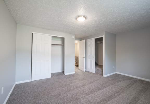 An empty living room with white doors and a carpeted floor at Willowbrooke Apartments, Brockport, New York, 14420
