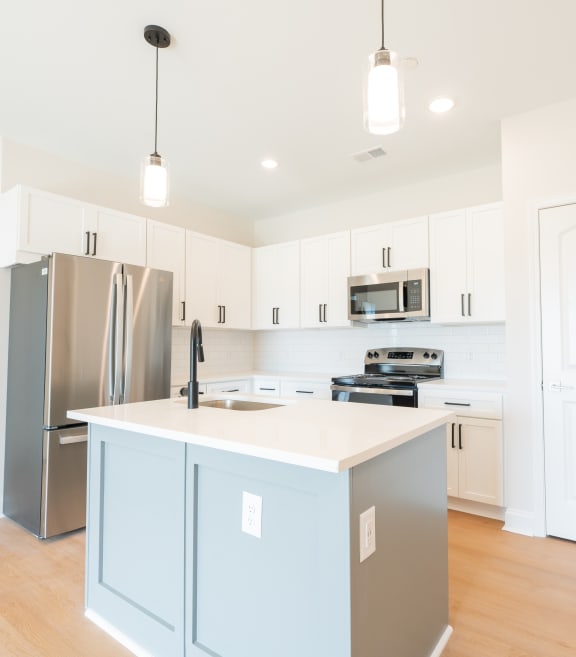 a large kitchen with white cabinets and stainless steel appliances