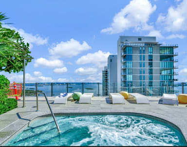 A pool with a slide and a building in the background.