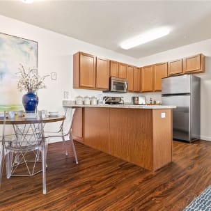 a kitchen with stainless steel appliances and a table with chairs