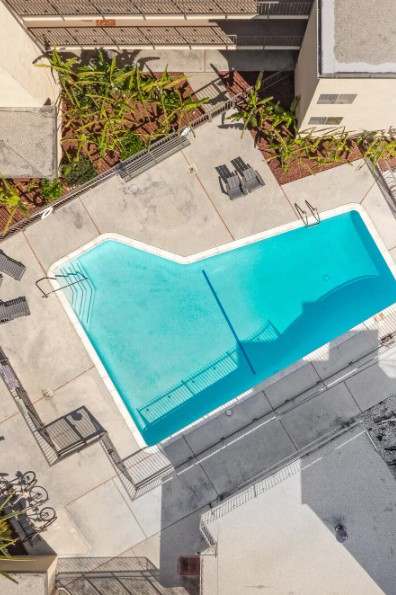 A small blue pool in a courtyard surrounded by buildings.