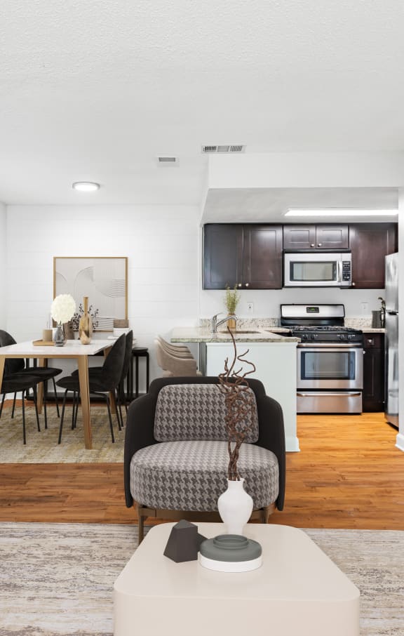 a living room and kitchen with white walls and hardwood floors