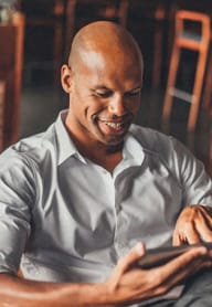a man sitting in a chair using a tablet computer