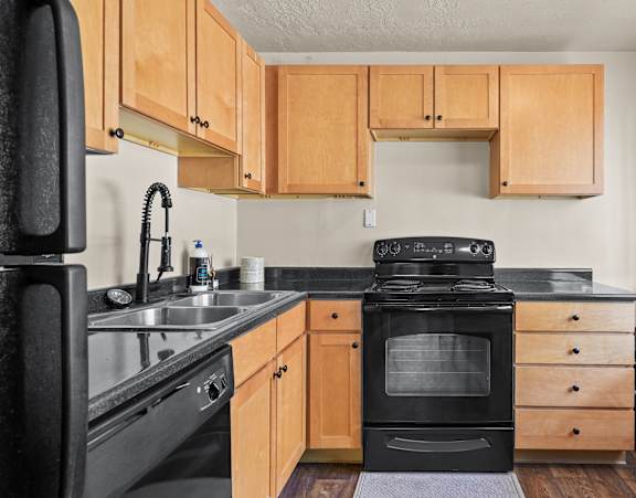 A kitchen with wooden cabinets and black appliances.