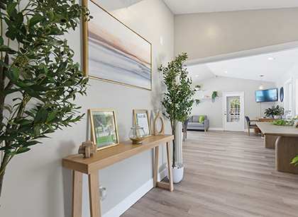 A room with a wooden bench and a painting on the wall.
