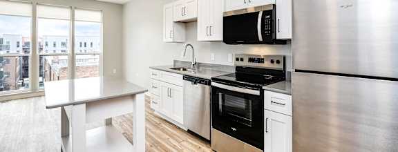 A modern kitchen with stainless steel appliances and white cabinetry.