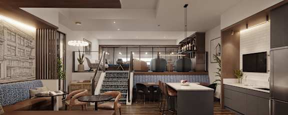 Modern kitchen area with tables and chairs and stairs leading up to a loft area.