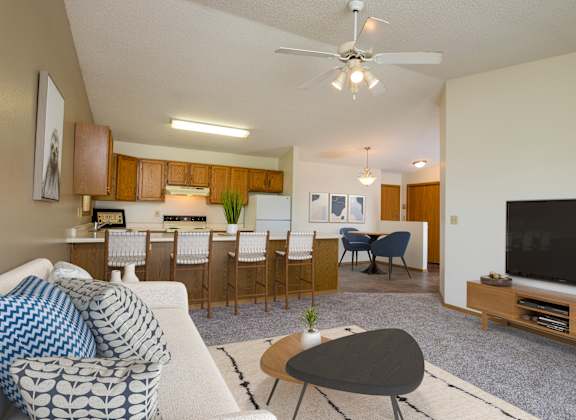 Flickertail I-VI Apartments |living room with a couch and a table in front of a tv