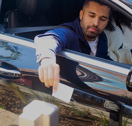 a man sticking his hand out the window of a car