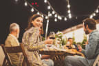 people sitting at a table with a glass of wine