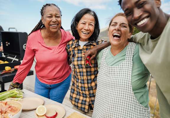 Four people are standing together and laughing.