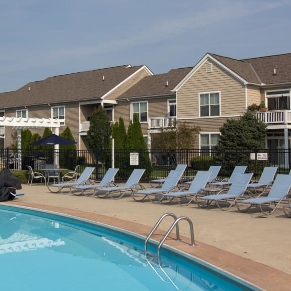 a swimming pool with chaise lounge chairs in front of apartment buildings  at Grove City Summit, Ohio, 43123