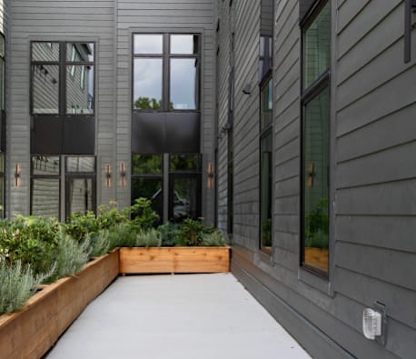 A modern building with a grey exterior and a wooden planter box in front.