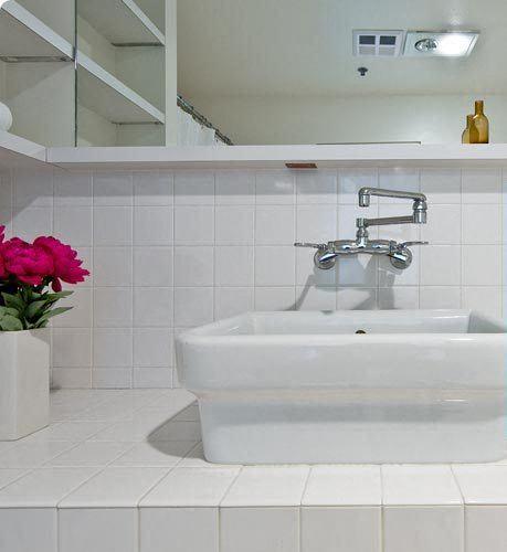 a white bathroom with a sink and a mirror