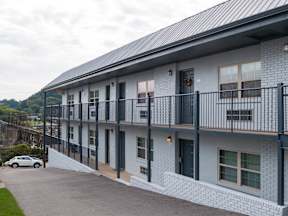 A grey building with a black metal railing on the balcony.at Maplehurst Apartments, Knoxville, TN 37902