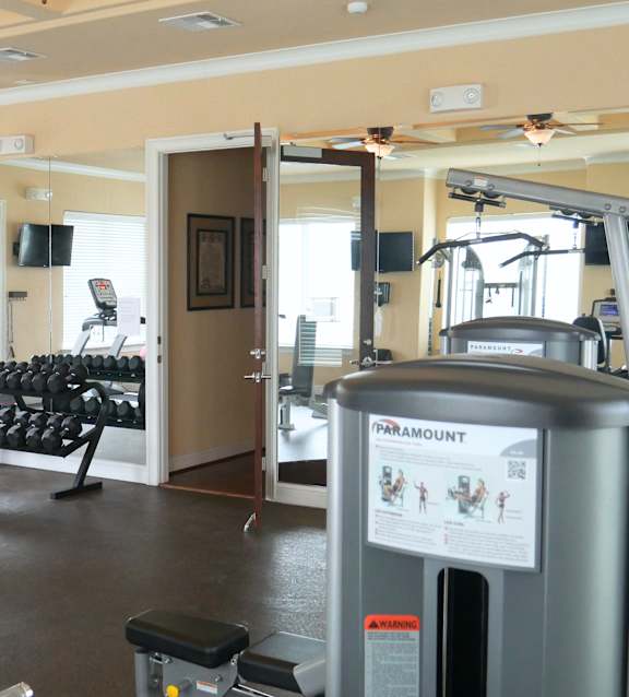 A gym with a variety of equipment including a treadmill and weights.
