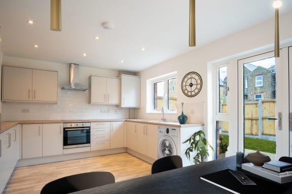 a kitchen with white cabinets and a black table and chairs