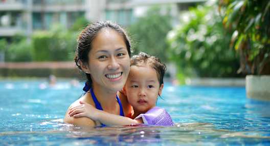 A woman and a child are in a pool.