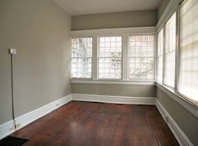 A room with a window and wooden floors.