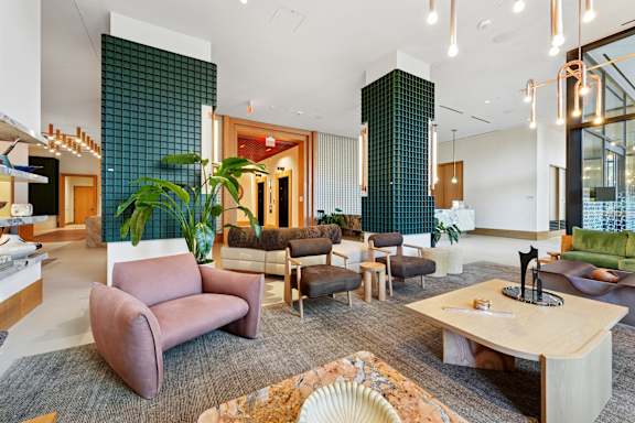 A modern living room with a variety of seating options and a large window.