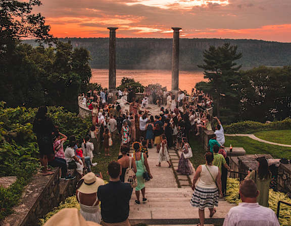 a crowd of people walking down the steps at sunset