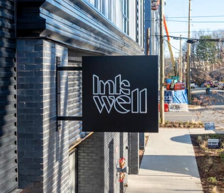 A sign that says Imb Well is hanging on a building.