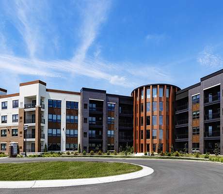 A modern apartment complex with a curved building and a round building.