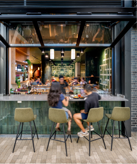 people sitting at the bar of a restaurant