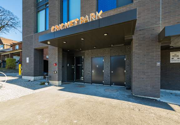 The Cricket Park building is made of brick and has a large entrance.