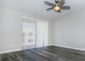 Thumbnail 8 of 22 - an empty living room with wood flooring and a ceiling fan