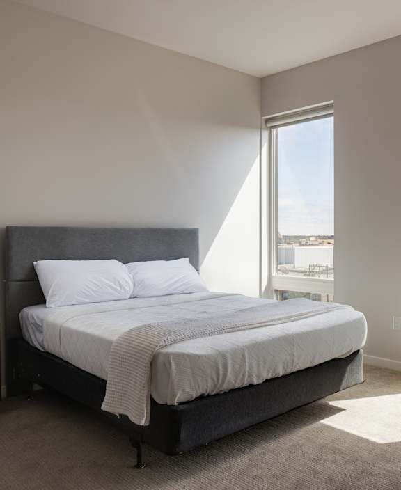 A bedroom with a large bed and a view of the city.