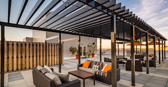 a patio with couches and a table under awning