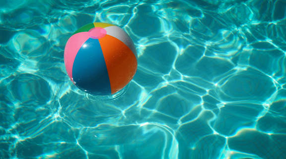 A beach ball floating in a pool of water.
