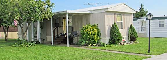 A house with a porch and a flag on a pole.