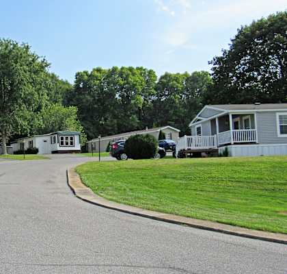 A street view of a residential area with houses and trees.