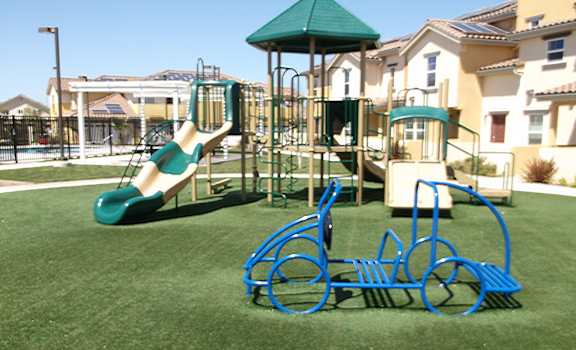 Alternate picture of playground showing pretend car, slides, and stairs to the covered playground deck.