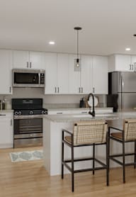 A modern kitchen with a large island and four chairs.