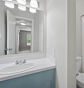 A bathroom with a white tub, toilet, and sink.